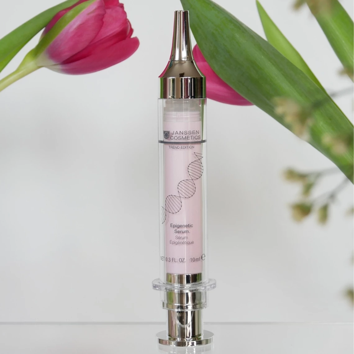 Sérum épigénétique placé sur un fond blanc avec des tulipes