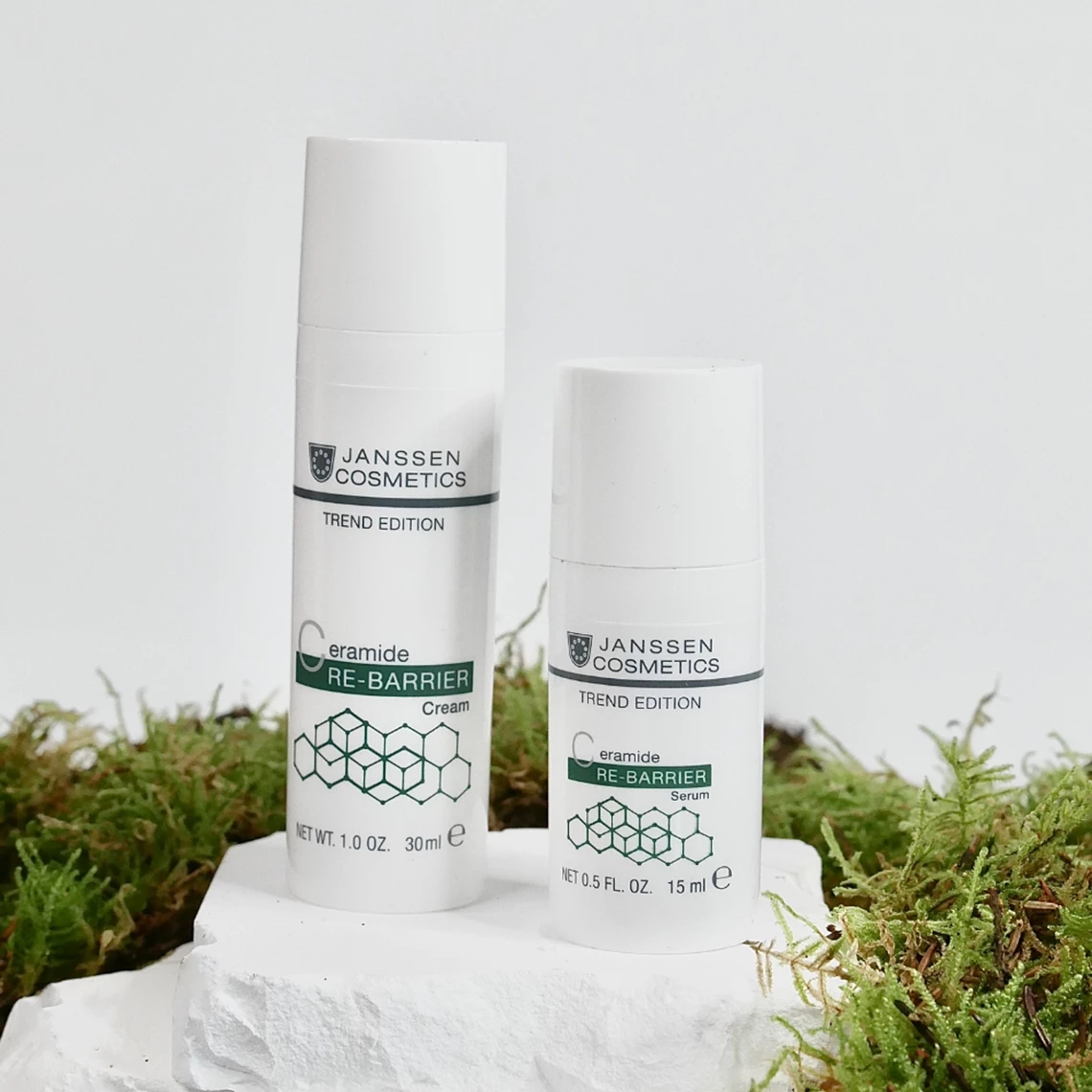 Deux produits Janssen Cosmetics Ceramide Re-Barrier : sérum (15 ml) et crème (30 ml) posés sur de la mousse